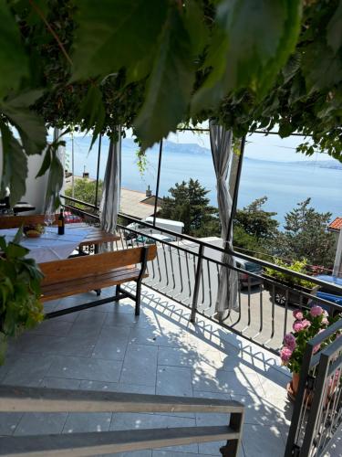 een houten bank op een balkon met uitzicht op de oceaan bij Apartment Sanja in Senj