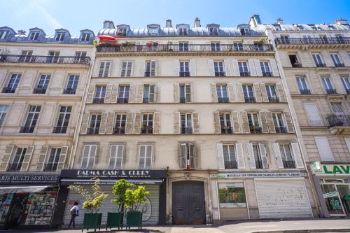 - un grand bâtiment dans une rue de la ville avec des boutiques dans l'établissement Charmant Studio, à Paris