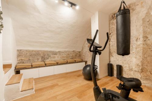 - une salle de sport avec un tapis de course et un banc dans une pièce dans l'établissement Merveilleux appartement en pleins coeurs du Marais, à Paris