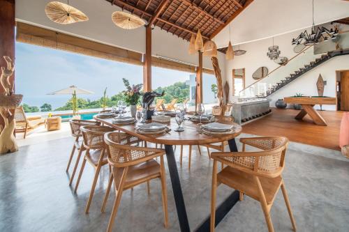 a dining room with a table and chairs and a pool at Villa Irrawaddy Lovina in Lovina