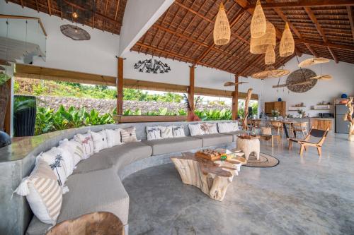 a living room with a couch and a table at Villa Irrawaddy Lovina in Lovina