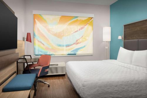 a hotel room with a bed and a chair at Tru by Hilton Jacksonville West I 295 in Jacksonville