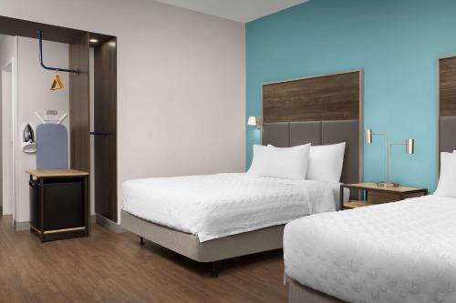 a hotel room with two beds and a blue wall at Tru by Hilton Jacksonville West I 295 in Jacksonville