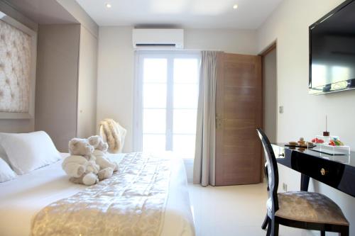 a teddy bear sitting on a bed in a bedroom at Hôtel Marinca & Spa in Olmeto