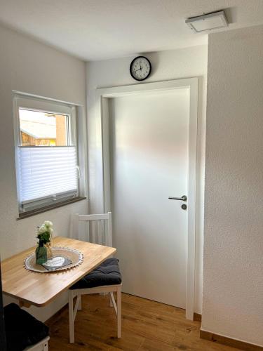 a room with a table and a clock on the door at Gemse-Schneiders Wohnen auf dem Bauernhof in Schollbrunn
