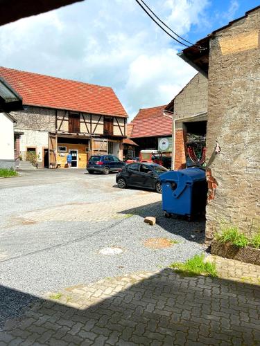 a blue trash can sitting on the side of a street at Gemse-Schneiders Wohnen auf dem Bauernhof in Schollbrunn