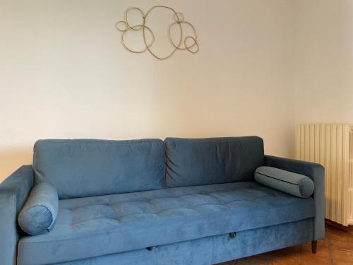 a blue couch in a living room with a chandelier at Casa Carlotte - Lago di Garda in Lazise