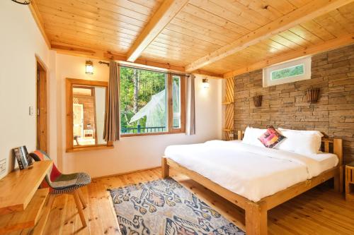 a bedroom with a bed and a desk and a window at Jomotel Dayaar - An Apple Orchard Villa in Theog