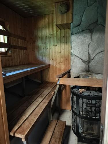 an empty sauna with a bench and a rock at Rapula 1makuuhuone ja parvi in Ylläsjärvi