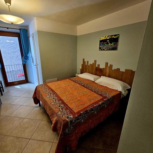 a bedroom with a bed with a wooden head board at Borgo Paradiso Guest House in Maccagno Inferiore