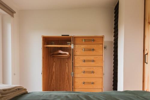 a bedroom with a wooden cabinet and a dresser at Śliwkowy Sad-Plum Orchard-Jura in Mirów