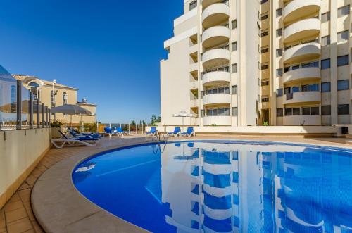 a large swimming pool in front of a building at TURIM Algarve Mor Apartamentos Turísticos in Portimão