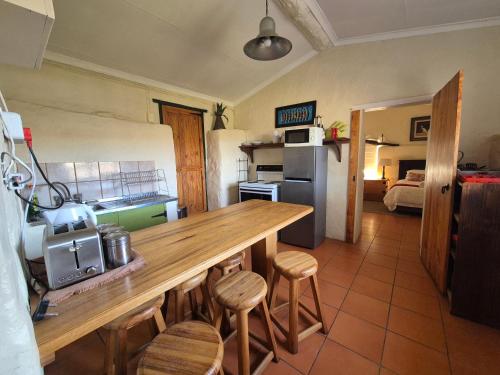 a kitchen with a counter and stools in a room at Ganora Guest Farm, Camping and Excursions in Nieu-Bethesda