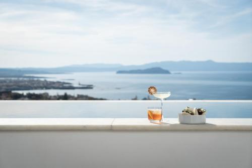 a glass of wine on a ledge with a view of the water at Lagon Life Spirit Boutique Hotel - Adults Only in Chania Town
