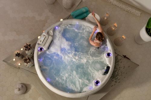 a woman is in a bath tub in a bathroom at Lagon Life Spirit Boutique Hotel - Adults Only in Chania Town