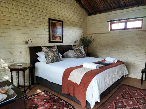 a bedroom with two beds in a brick wall at Ganora Guest Farm, Camping and Excursions in Nieu-Bethesda