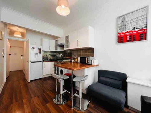 a kitchen with a counter and a table and chairs at St Pancras Private Rooms in London