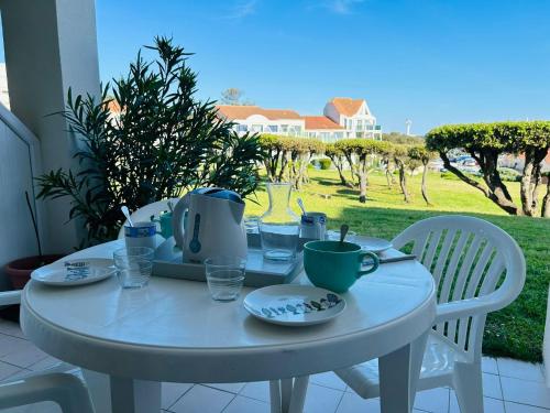 - une table blanche avec des assiettes et des tasses sur une terrasse dans l'établissement 