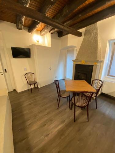 a dining room with a table and chairs and a fireplace at Porto 03 in Albosaggia