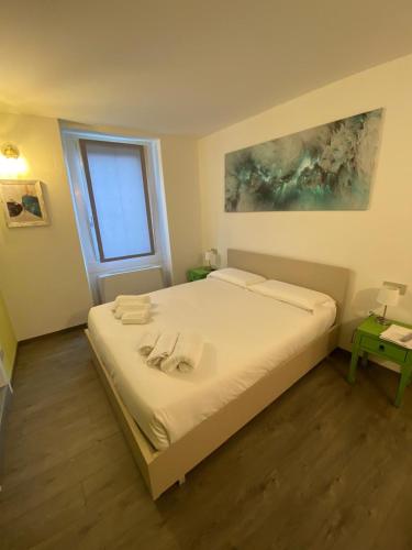 a bedroom with a white bed with a window at Porto 03 in Albosaggia