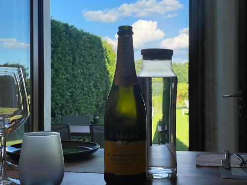 a bottle of wine sitting on a table next to a glass at Casa Carlotte - Lago di Garda in Lazise