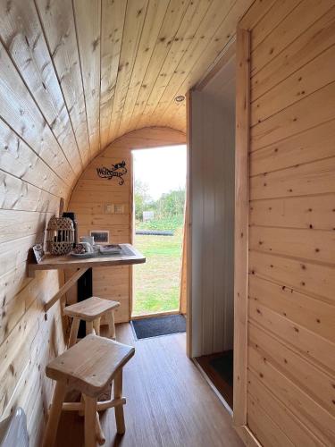 une cuisine dans une cabane en rondins avec une table et des bancs dans l'établissement Auberge de l'Hirondelle, à Saint-Cirq