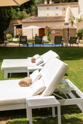a group of white beds sitting on the grass at Hotel Convent de Begur in Begur