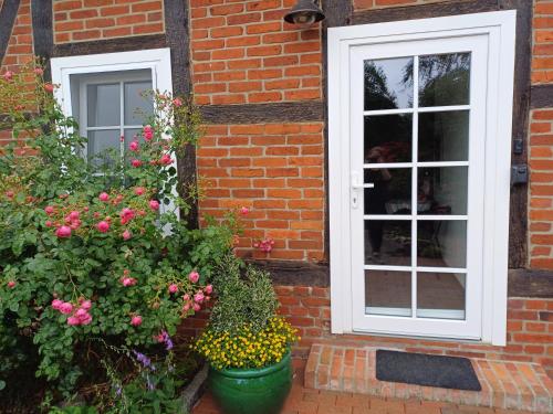 a brick house with two windows and flowers at Ferienwohnung Wussegel in Hitzacker