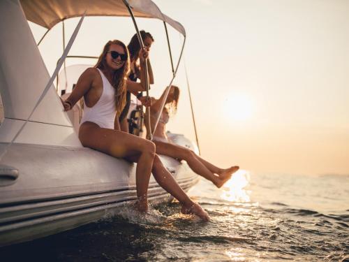 grupa ludzi siedzących na łodzi w wodzie w obiekcie VACATION MARBELLA I Brand New Terrazas de Banús Apt, 24-7 Security, a minute from the Marina, The Sea and Luxury Shopping w Marbelli