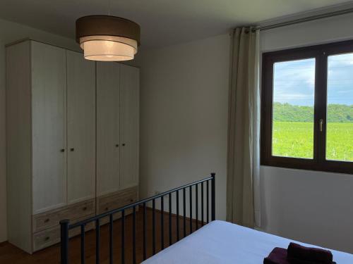a bedroom with a bed and a window with a field at Casa Carlotte - Lago di Garda in Lazise