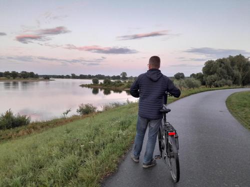 a man walking a bike on a path next to a river at Ferienwohnung Wussegel in Hitzacker
