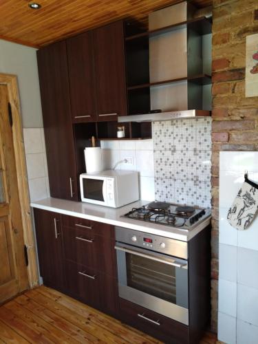 a kitchen with a stove and a microwave at Viktorijas dārzs in Liepāja