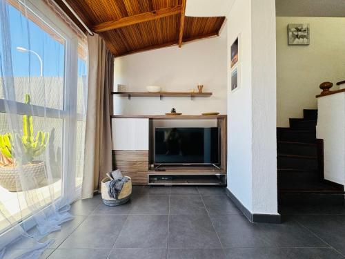 a living room with a television and a staircase at Bungalow Casita in Maspalomas