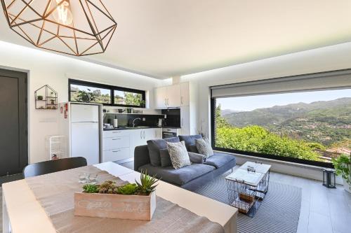a kitchen and living room with a large window at Casas das Olas in Arcos de Valdevez