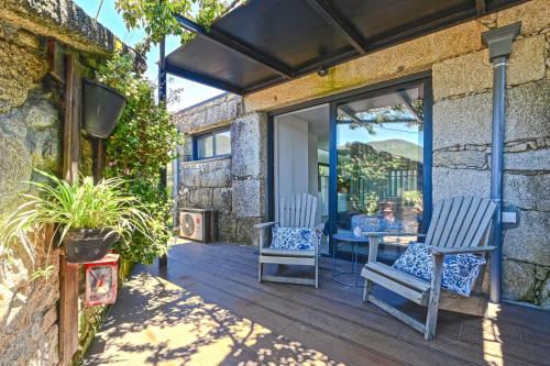 a patio with two chairs and a table at Casas das Olas in Arcos de Valdevez