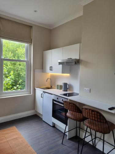 a kitchen with white cabinets and a sink and a stove at The Ivy Apartments in Bournemouth
