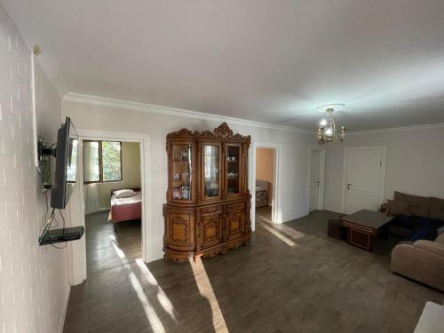 a living room with a large wooden cabinet at В ГОСТЯХ У РУСЛАНА in Gonio