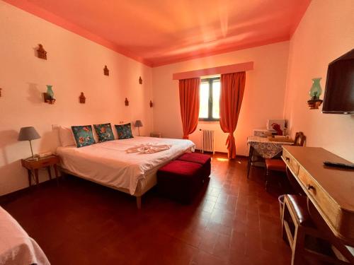 a bedroom with a bed and a desk and a television at Casa Santo António in São Brás de Alportel
