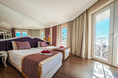 una camera d'albergo con due letti e una grande finestra di La Boutique Hotel & Suites - Adults Only a Antalya (Adalia)