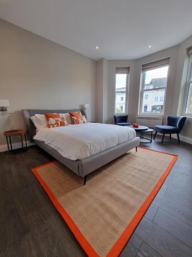 a bedroom with a large bed with an orange rug at The Ivy Apartments in Bournemouth