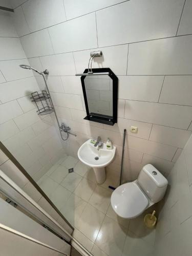 a bathroom with a sink and a toilet and a mirror at В ГОСТЯХ У РУСЛАНА in Gonio