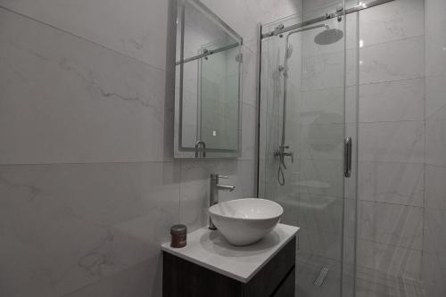 a bathroom with a sink and a glass shower at One90 Apartment in Lagos
