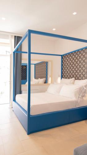 a bedroom with a blue canopy bed with white pillows at PALAZZO SAN ROCCO in Sperlonga