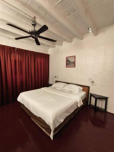 a bedroom with a bed with a ceiling fan at Red Inn Court in George Town