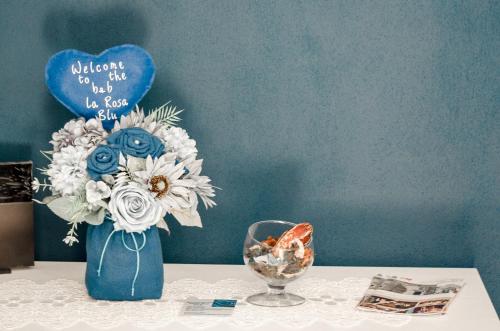 a blue vase with flowers on a table at La Rosa Blu in Gerace
