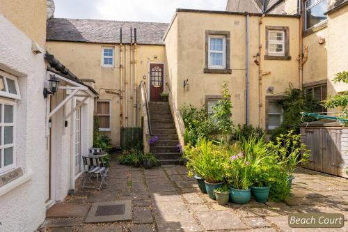 an alley with some plants in front of some buildings at Beach Court in North Berwick