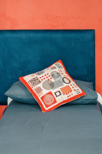 a pillow sitting on top of a bed at La Rosa Blu in Gerace
