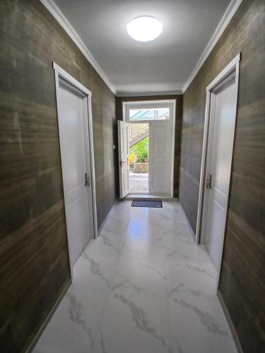 an empty hallway with two doors and a tile floor at Rabat Funicular in Akhaltsikhe