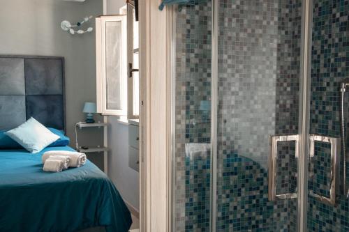 a bedroom with a shower and a bed with a glass door at La Rosa Blu in Gerace