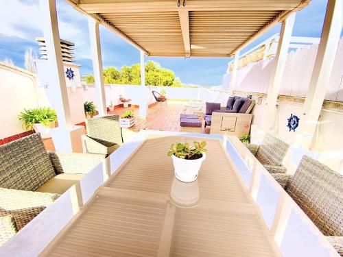 Una mesa de patio con sillas y una planta en maceta encima. en TheHavenEscape Penthouse Pool & Sea View near Barcelona, en Comarruga